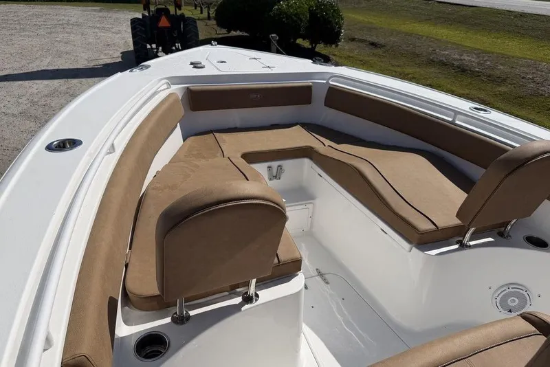 Slide: The Image of 2024 Sea Hunt Ultra 265 SE boat with tan cushioned seating and white deck. - 13