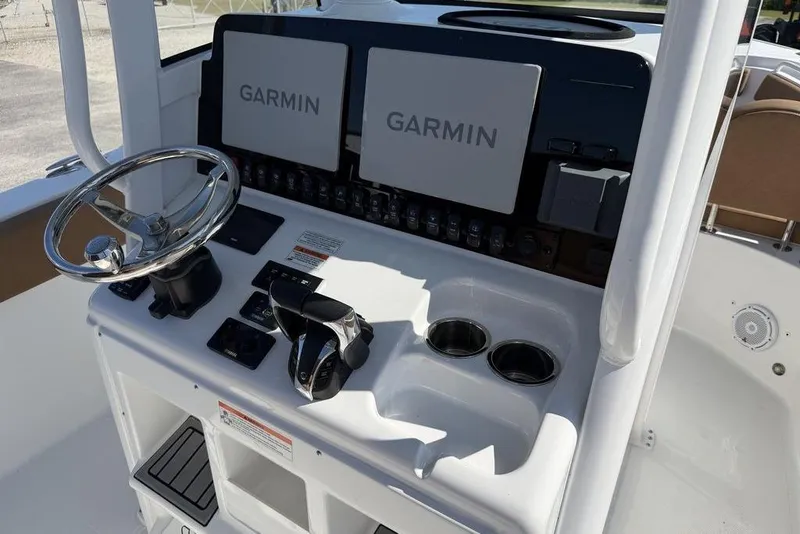 Slide: The Image of 2024 Sea Hunt Ultra 265 SE boat dashboard with dual Garmin displays and steering wheel. - 19