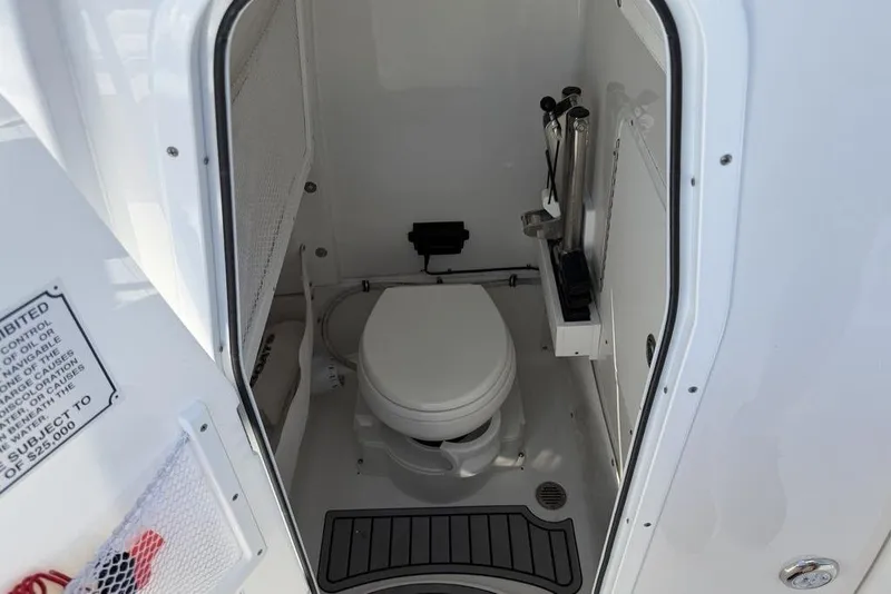 Slide: The Image of 2024 Sea Hunt Ultra 265 SE boat interior with compact marine toilet. - 2