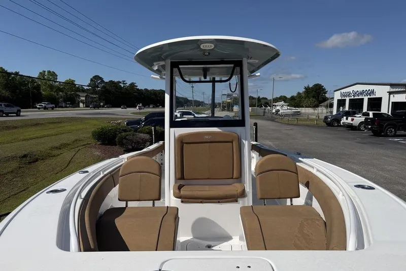 Slide: The Image of 2024 Sea Hunt Ultra 265 SE boat with tan seating, displayed outdoors. - 21