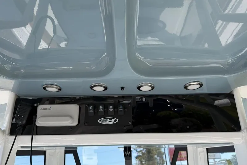Slide: The Image of 2024 Sea Hunt Ultra 265 SE dashboard with Garmin device and control panel. - 23