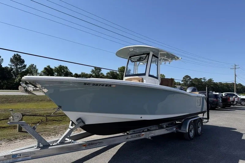 Slide: The Image of 2024 Sea Hunt Ultra 265 SE boat on trailer, parked outdoors under clear sky. - 24
