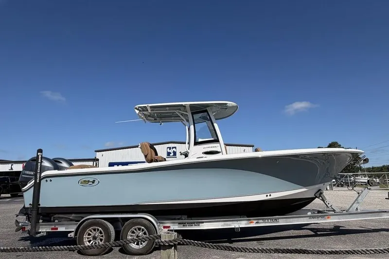 Slide: The Image of 2024 Sea Hunt Ultra 265 SE boat on trailer under clear blue sky. - 3