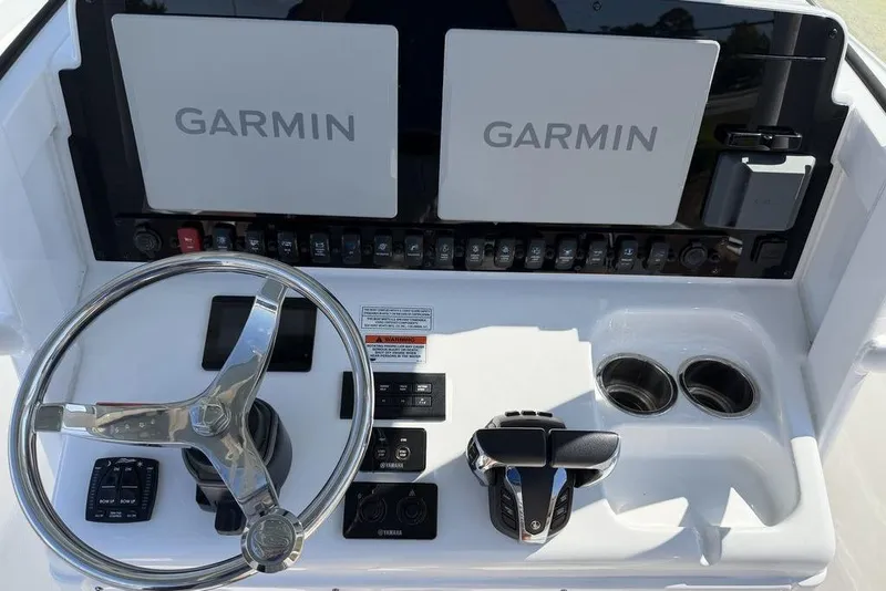 Slide: The Image of 2024 Sea Hunt Ultra 265 SE boat dashboard with Garmin displays and steering wheel. - 5