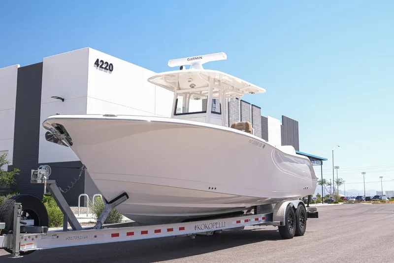 The Image of 2024 NauticStar 292 Legacy boat on trailer outside modern building. - 0