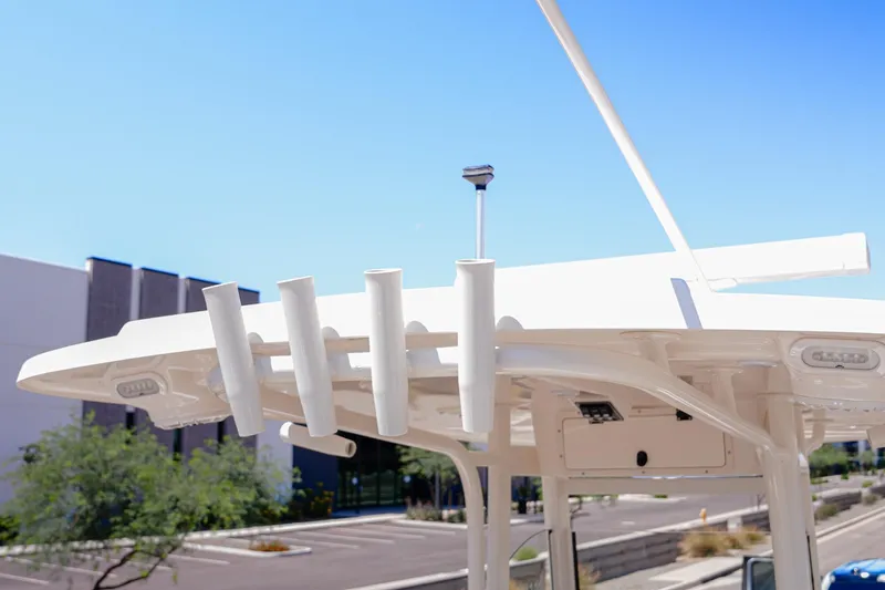 Slide: The Image of 2024 NauticStar 292 Legacy boat with rod holders and antenna against blue sky. - 14