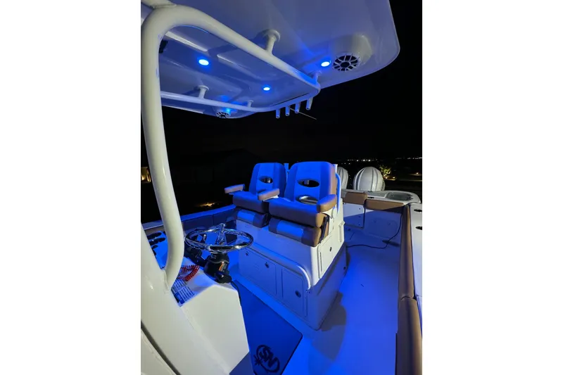 Slide: The Image of 2024 NauticStar 292 Legacy boat interior with blue LED lighting at night. - 18
