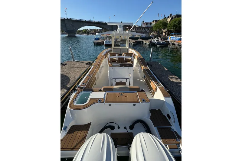 Slide: The Image of 2024 NauticStar 292 Legacy boat docked by a scenic waterfront bridge. - 20