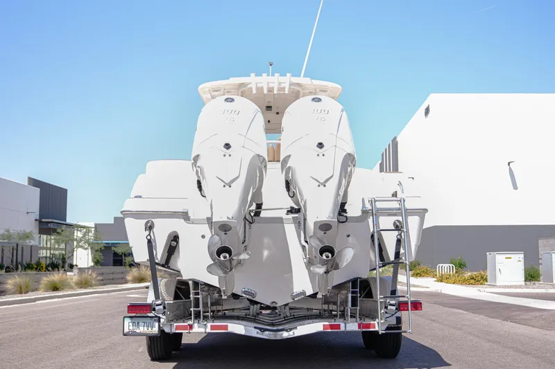 Slide: The Image of 2024 NauticStar 292 Legacy boat with dual engines on a trailer, rear view. - 25