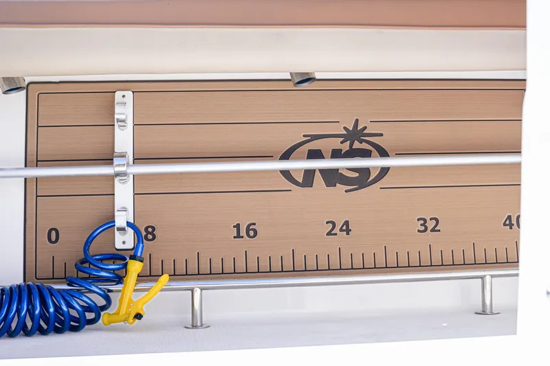Slide: The Image of 2024 NauticStar 292 Legacy boat ruler with coiled blue hose and yellow nozzle. - 29