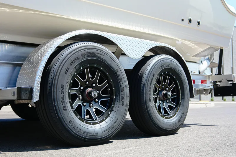 Slide: The Image of Trailer wheels of 2024 NauticStar 292 Legacy boat on pavement. - 45