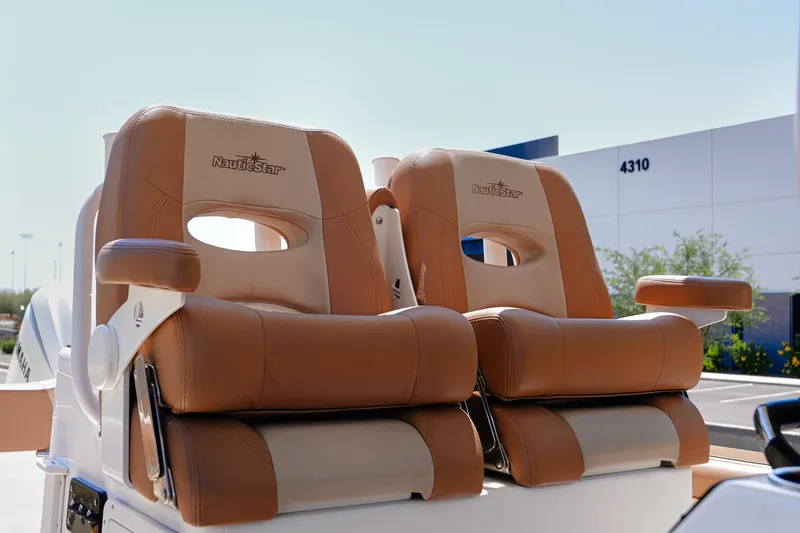 Slide: The Image of 2024 NauticStar 292 Legacy boat seats, tan leather, outdoor setting. - 5