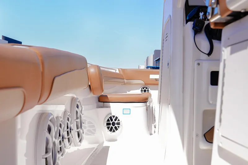 Slide: The Image of 2024 NauticStar 292 Legacy boat interior with tan seating and speakers. - 8