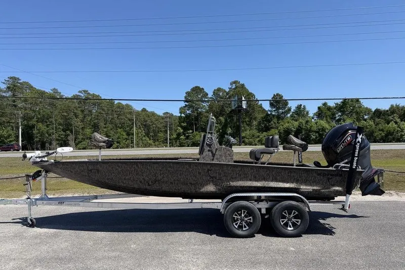 The Image of 2026 Xpress H22B Bay boat on trailer, parked outdoors under clear blue sky. - 0