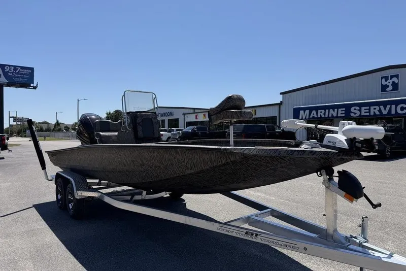Slide: The Image of 2026 Xpress H22B Bay boat on trailer outside marine service center. - 4
