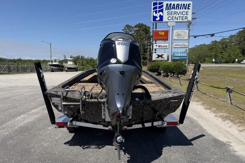 Slide: The Image of 2026 Xpress H22B Bay boat at Marine Service Center with powerful outboard motor. - 9