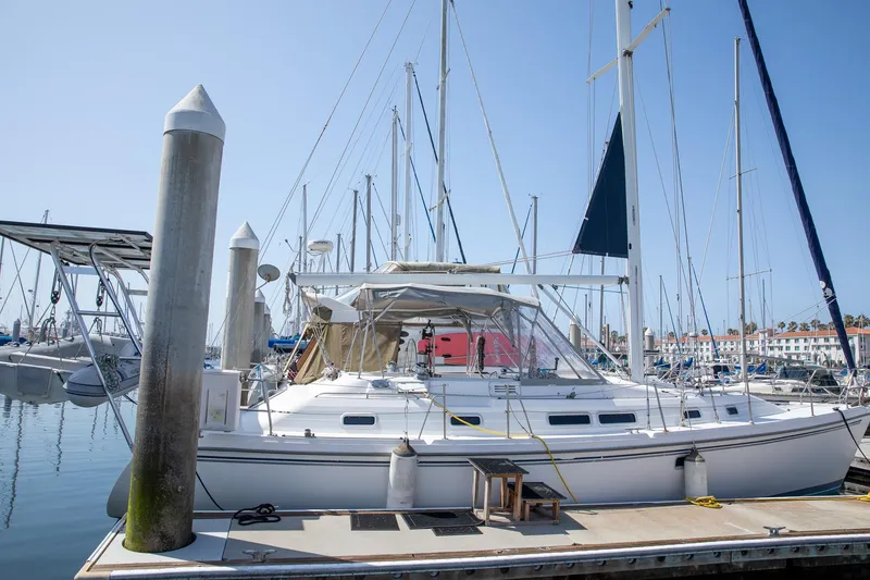 The Image of 1994 Morgan Catalina 38 sailboat docked at marina, surrounded by other boats. - 0