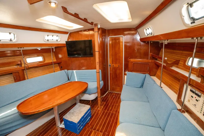 Slide: The Image of Interior of a 1994 Morgan Catalina 38 sailboat with wooden finishes and blue seating. - 24