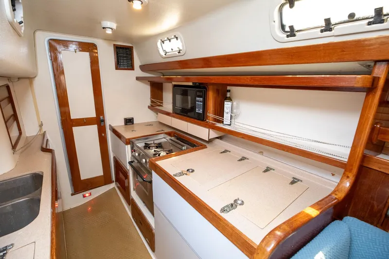 Slide: The Image of 1994 Morgan Catalina 38 yacht interior with kitchen, stove, microwave, and seating area. - 29