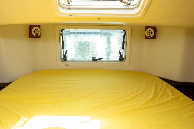 Slide: The Image of Cozy cabin interior of 1994 Morgan Catalina 38 sailboat with wooden paneling and nautical-themed bedding. - 49