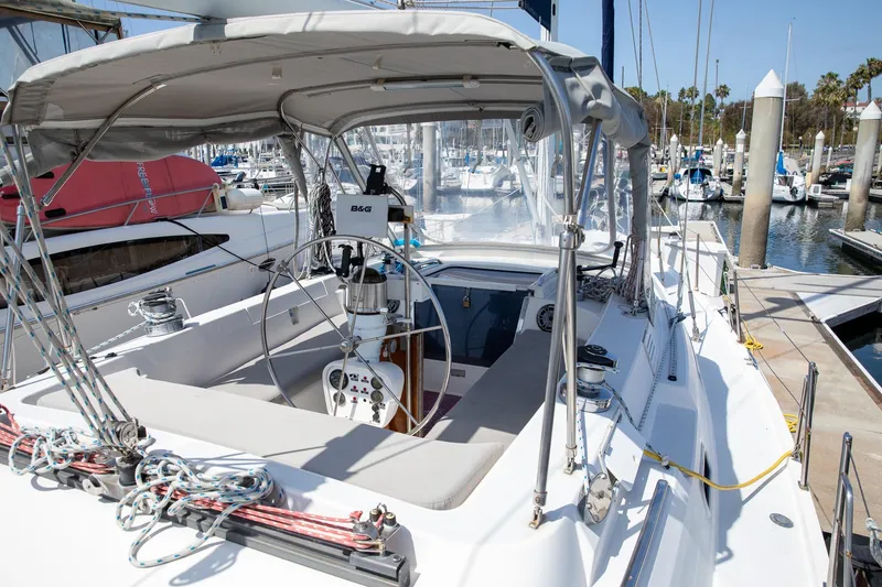 Slide: The Image of 1994 Morgan Catalina 38 sailboat docked at marina, featuring spacious cockpit and modern navigation equipment. - 6