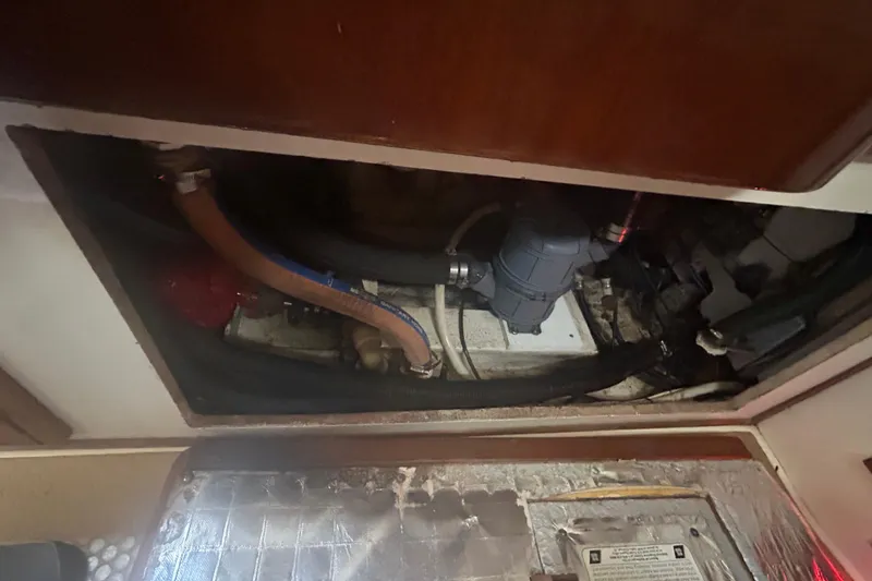 Slide: The Image of Engine compartment of a 1994 Morgan 38 sailboat, showing hoses and mechanical components. - 62