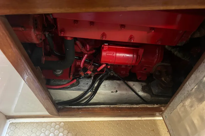 Slide: The Image of Engine compartment of a 1994 Morgan 38 boat, featuring red mechanical components. - 63