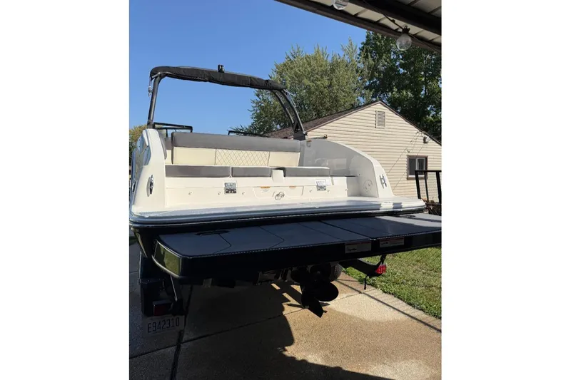 Slide: The Image of 2023 Bayliner DX 2250 boat rear view with swim platform in driveway. - 10