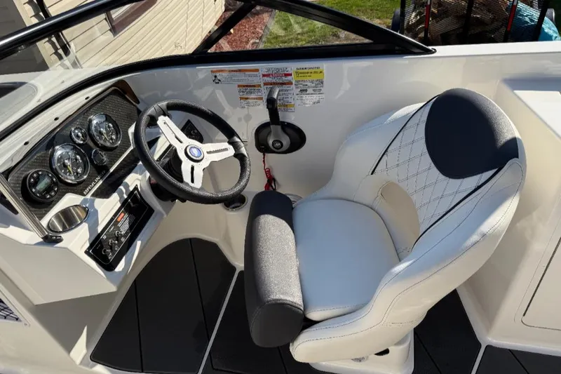 Slide: The Image of 2023 Bayliner DX 2250 boat cockpit with steering wheel and captain's chair. - 14