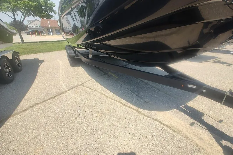 Slide: The Image of 2023 Bayliner DX 2250 boat on trailer, parked on a sunny day. - 17