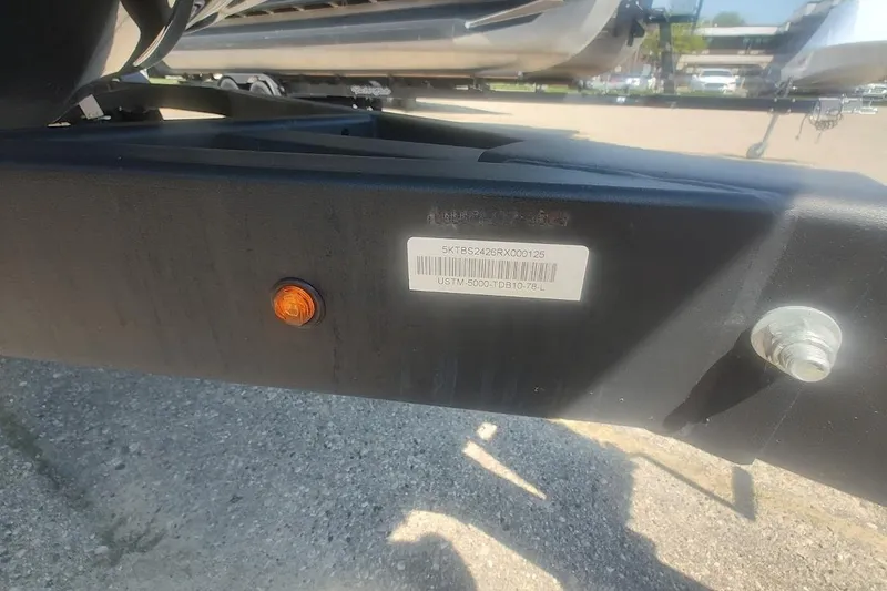 Slide: The Image of Trailer frame with VIN label and orange reflector for 2023 Bayliner DX 2250 boat. - 18