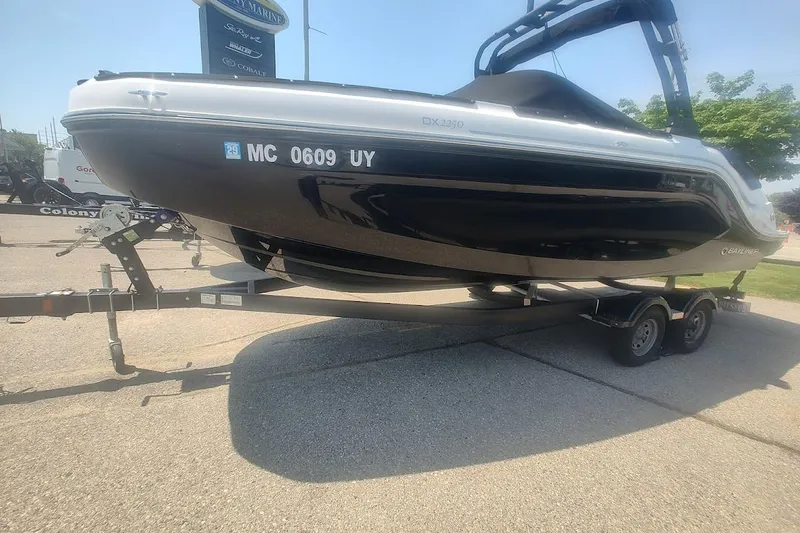 Slide: The Image of 2023 Bayliner DX 2250 boat on trailer, displayed outdoors in a sunny setting. - 3
