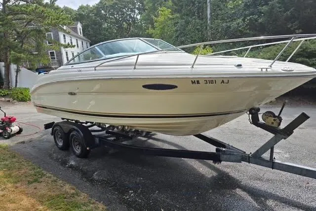 Slide: The Image of 2004 Sea Ray 215 Weekender boat on trailer, parked outdoors. - 2