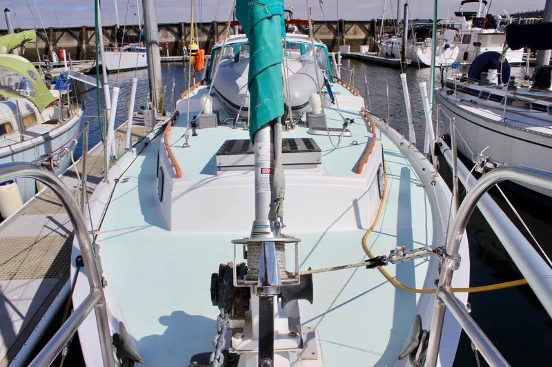 Slide: The Image of 1975 Downeast 38 sailboat docked at a marina, showcasing deck and rigging. - 11