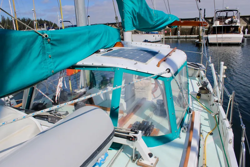 Slide: The Image of 1975 Downeast 38 sailboat with teal covers docked in a marina. - 13