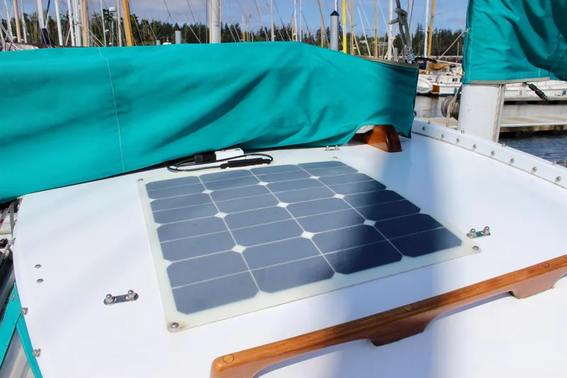 Slide: The Image of 1975 Downeast 38 sailboat with solar panel on deck, docked at marina. - 14