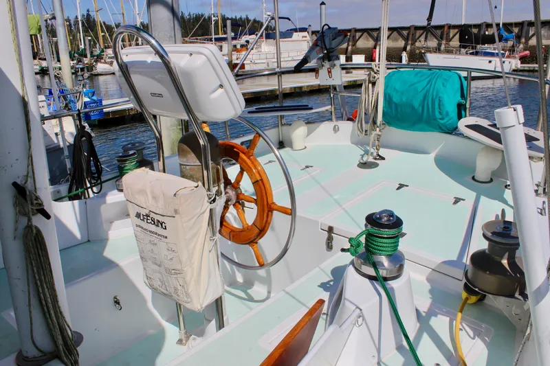 Slide: The Image of Cockpit of a 1975 Downeast 38 sailboat with wooden wheel and nautical equipment. - 16