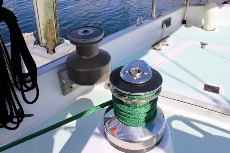 Slide: The Image of Winch on 1975 Downeast 38 sailboat deck with green rope, near water. - 18