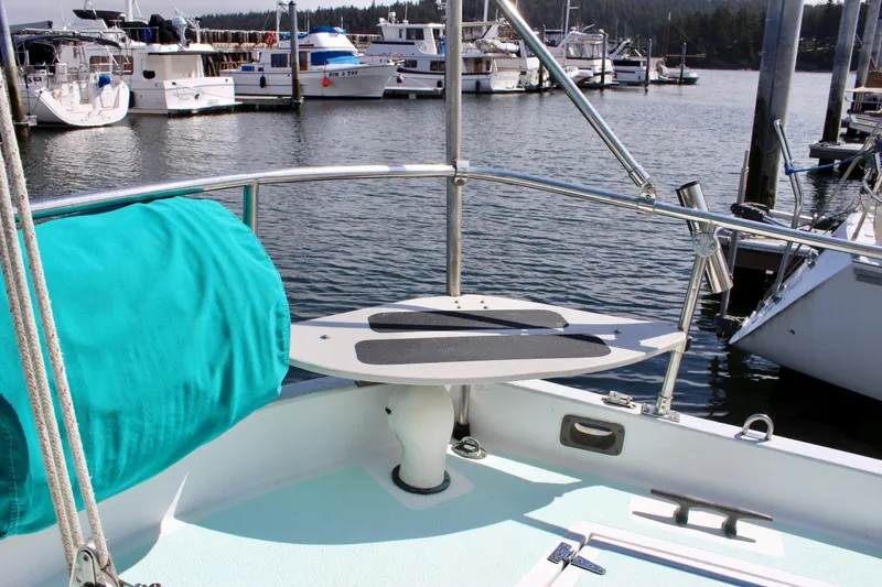 Slide: The Image of 1975 Downeast 38 sailboat deck with marina view, featuring teal cover and railing. - 20