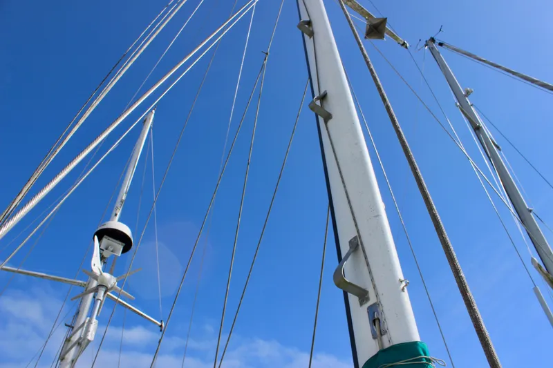 Slide: The Image of Masts and rigging of a 1975 Downeast 38 sailboat against a clear blue sky. - 27