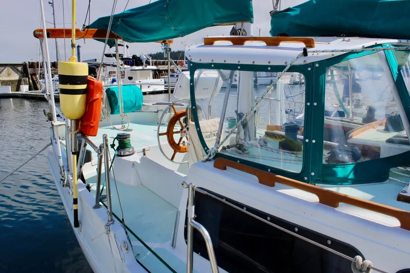 Slide: The Image of 1975 Downeast 38 sailboat docked, featuring teal canopy and wooden accents. - 3