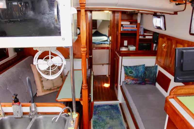 Slide: The Image of Interior of a 1975 Downeast 38 sailboat with cozy seating and wooden cabinetry. - 31