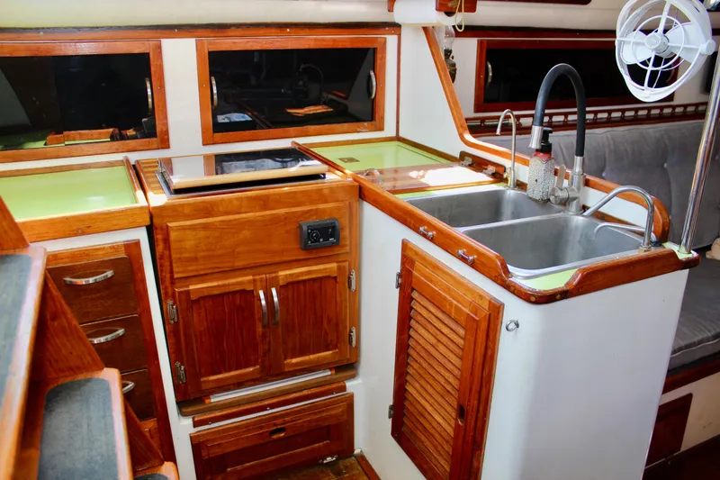 Slide: The Image of Interior of 1975 Downeast 38 yacht featuring a wooden kitchen with sink and stove. - 33