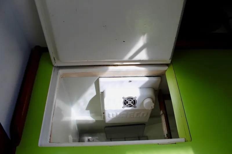 Slide: The Image of Open storage compartment on 1975 Downeast 38 boat with green countertop. - 37