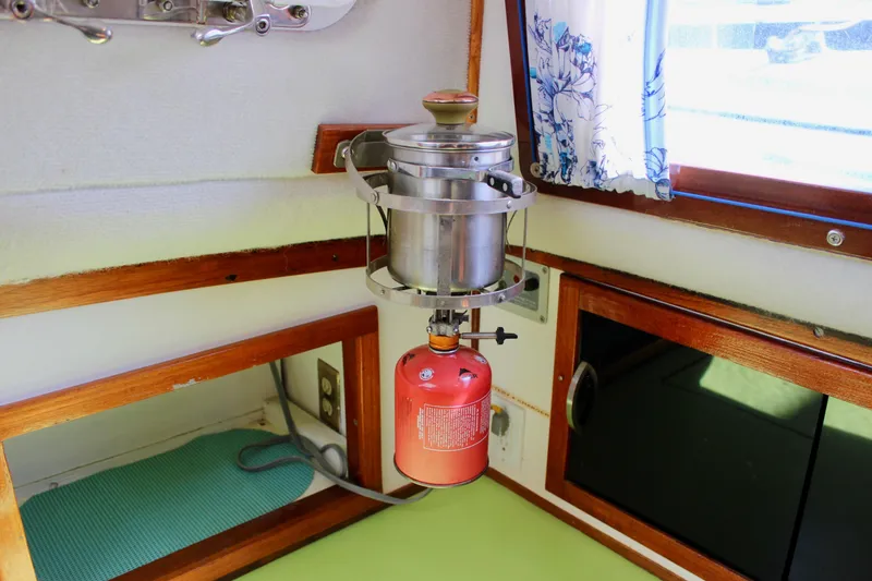 Slide: The Image of Vintage 1975 Downeast 38 boat interior with mounted stove and window curtain. - 38