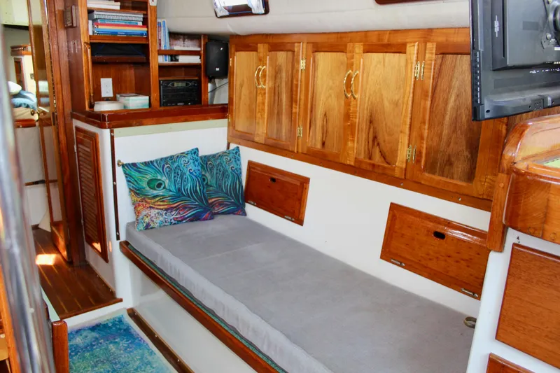 Slide: The Image of Interior of a 1975 Downeast 38 boat with wooden cabinets and a cozy seating area. - 51