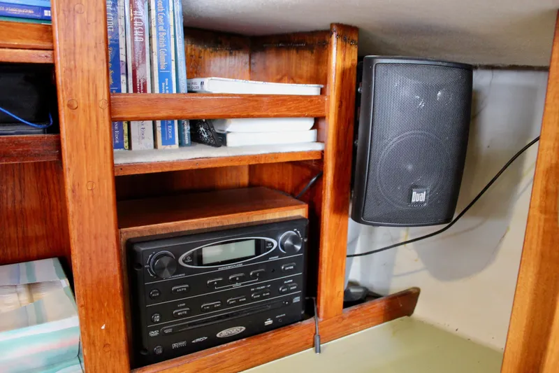 Slide: The Image of Wooden interior of a 1975 Downeast 38 boat with books, stereo, and speaker. - 55