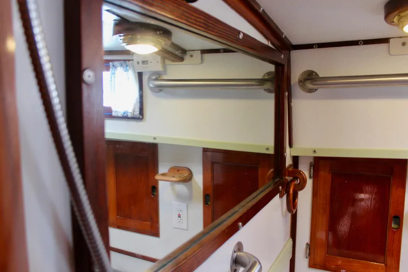 Slide: The Image of Interior of 1975 Downeast 38 boat, featuring wooden cabinetry and mirror. - 61
