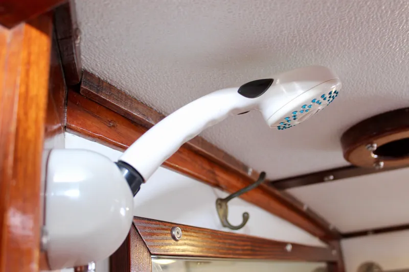 Slide: The Image of Showerhead in 1975 Downeast 38 boat interior, featuring wooden trim and ceiling mount. - 62