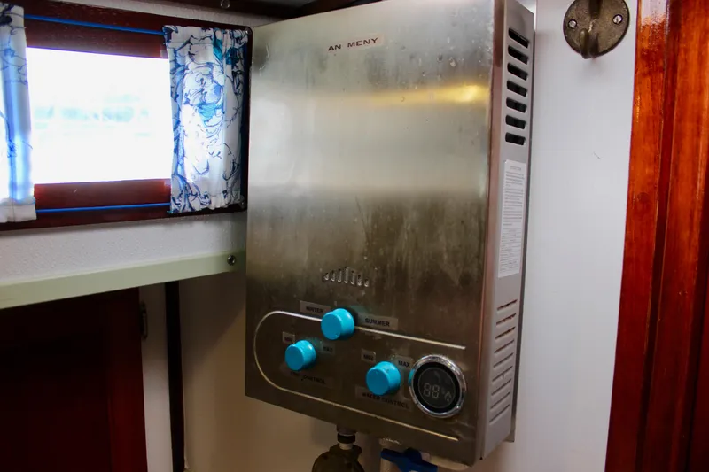 Slide: The Image of Stainless steel water heater inside a 1975 Downeast 38 boat cabin. - 63